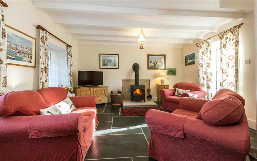 The lounge is comfortably furnished and decorated in cream, maximising the light. at Rainbow Cottage in Porthallow