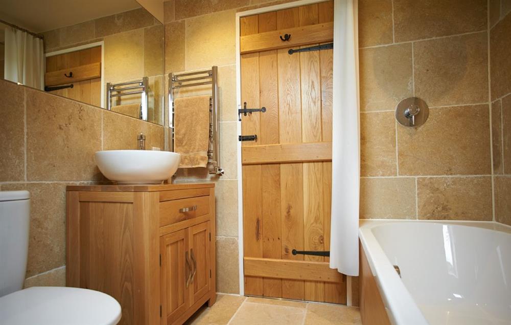 En-suite bathroom with shower over bath at Rampisham Hill Farm Barn, Hooke