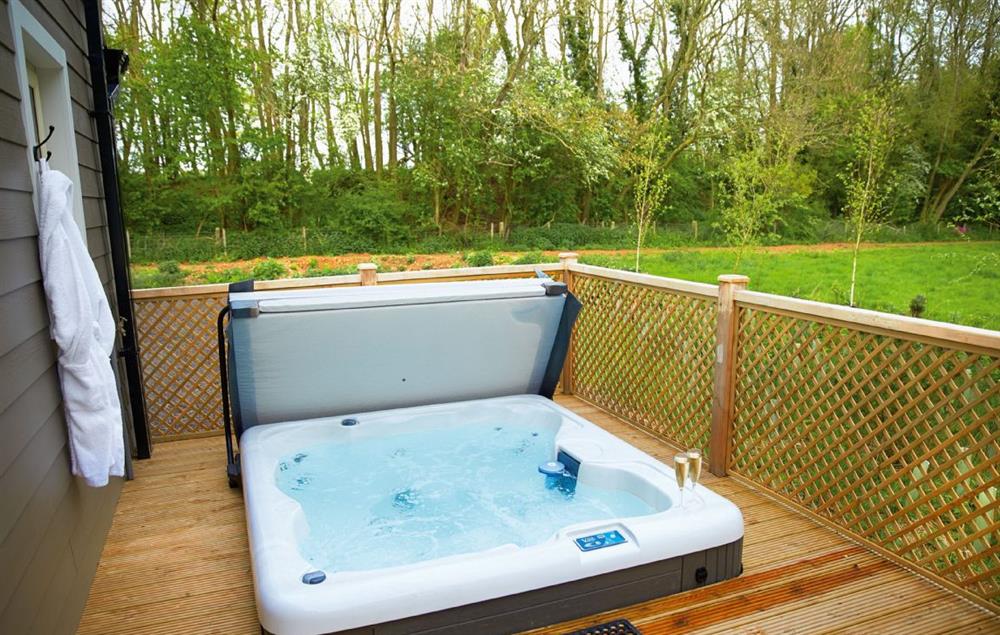 Decked area with garden furniture and hot tub at Ramson Lodge, Wakes Colne