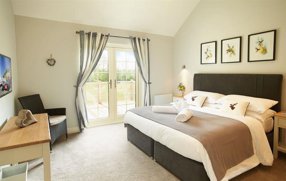 Master bedroom with 6’ bed and en-suite bathroom with separate shower at Ramson Lodge, Wakes Colne