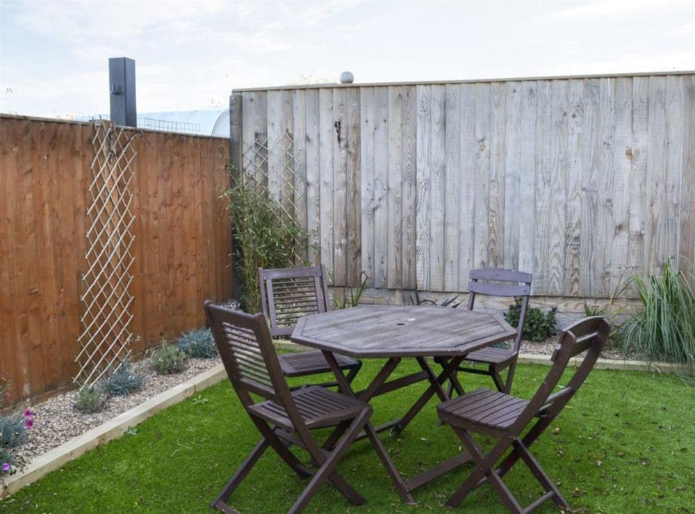 Enclosed courtyard with sitting-out area and garden furniture at Raveena in Anderby Creek, near Skegness, Lincolnshire