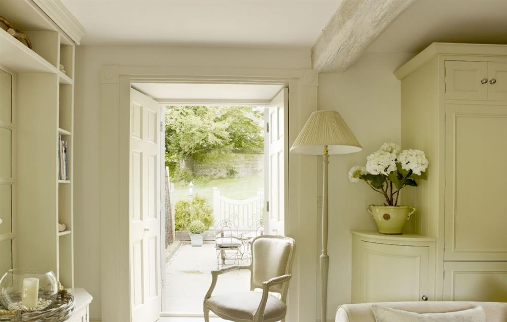 Doors from the open plan kitchen/sitting room open on to the courtyard garden at Rectory Cottage, Tinwell
