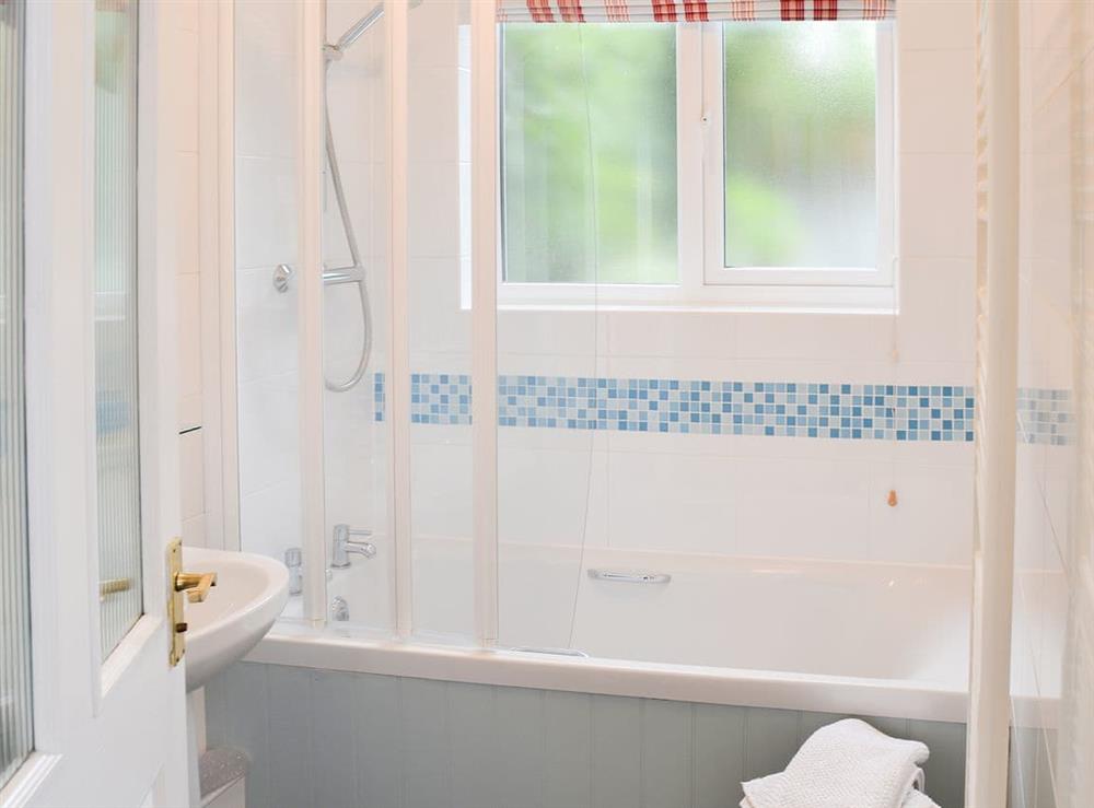Bathroom with shower over the bath at Red Brick Cottage in Lavenham, Suffolk