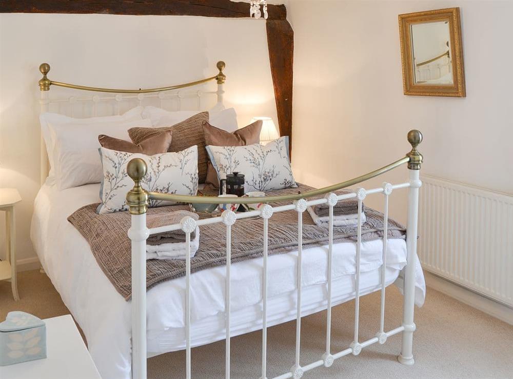 Double bedroom with antique style bed at Red Brick Cottage in Lavenham, Suffolk