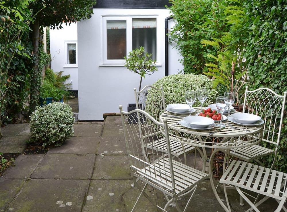 Private secluded paved garden with furniture at Red Brick Cottage in Lavenham, Suffolk