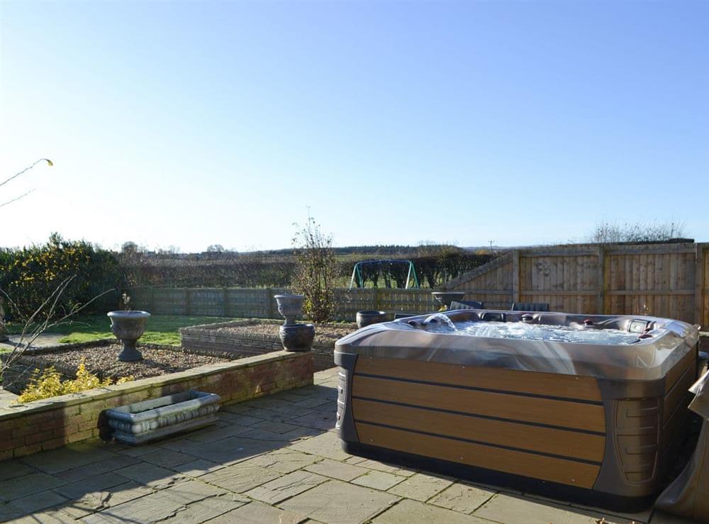 Private hot tub on a beautiful patio at Red Hen Cottage in Acklington, Northumberland