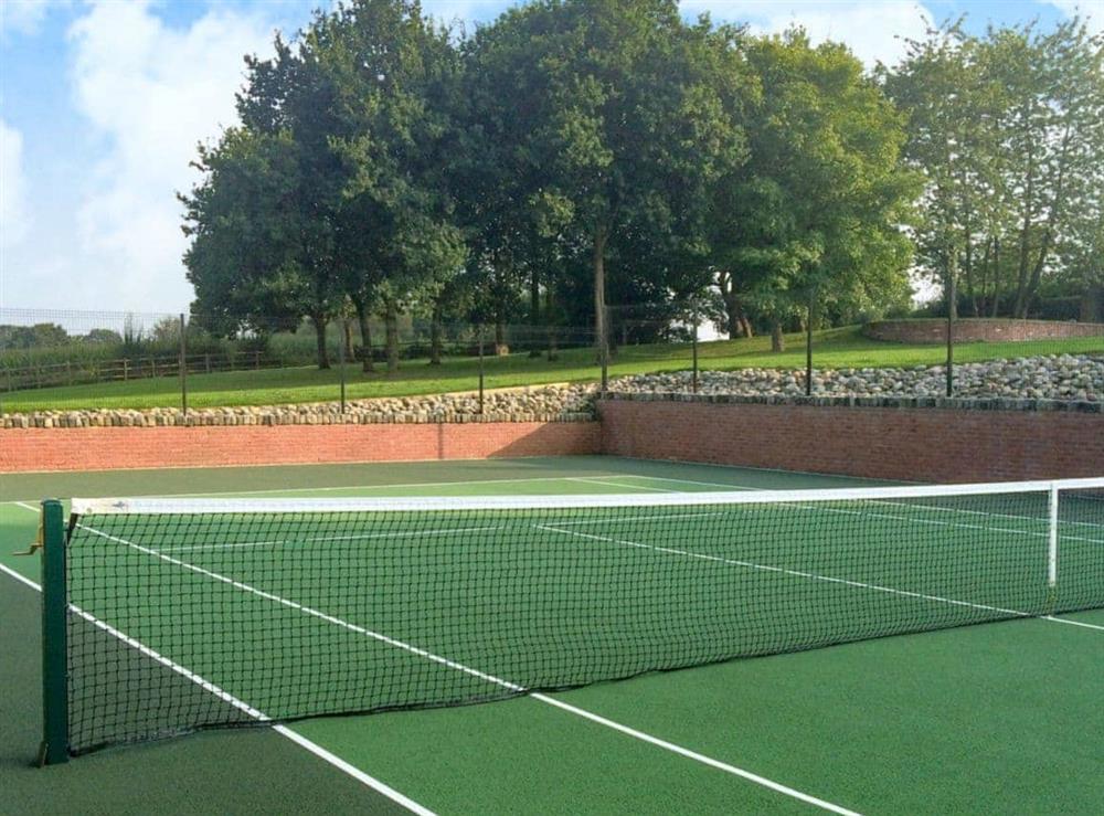 All-weather Tiger Turf sunken tennis court at Red House Farm Cottage in Whitegate, Cheshire., Great Britain