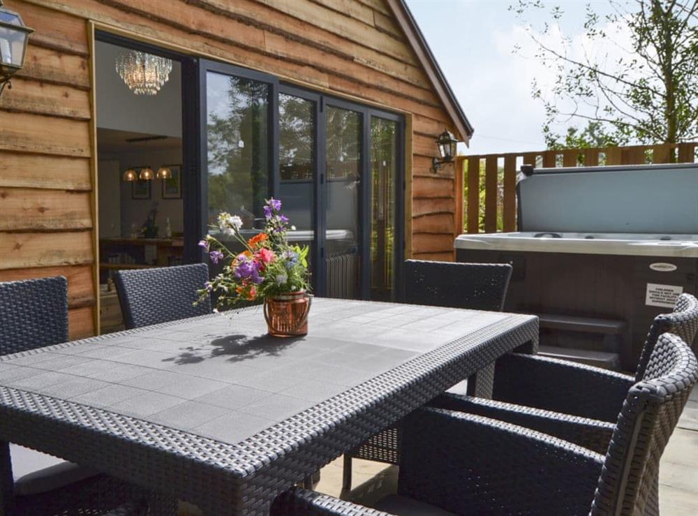 Decking area with garden furniture and hot tub at Red Squirrel Cottage in Whitwell, near Ventor, Isle of Wight