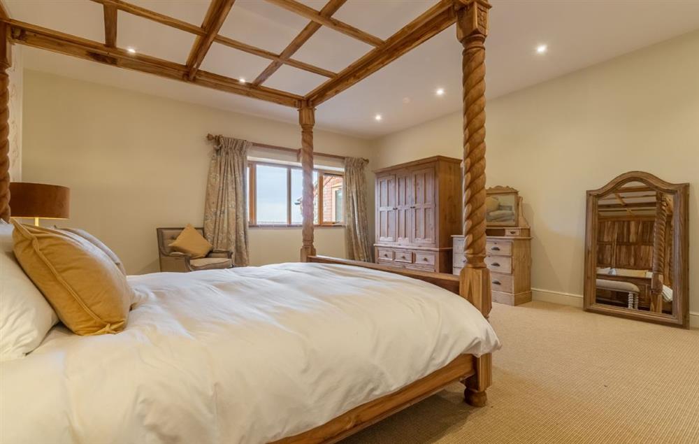 Master bedroom with 6’ super king-size four poster bed with views into the deer park. (photo 3) at Red Stag Lodge, Little Massingham
