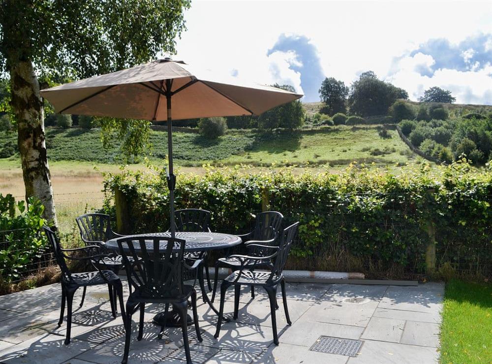 Paved patio area with table and chairs at Reivers Retreat in Denton Mill, near Brampton, Cumbria