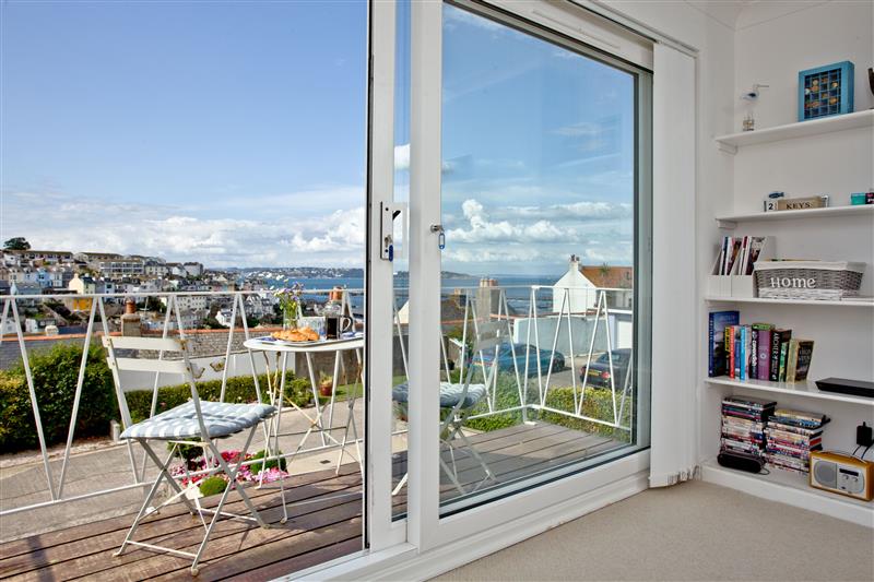 Living room with patio doors to the balcony at Rest A Shore, Brixham, Devon