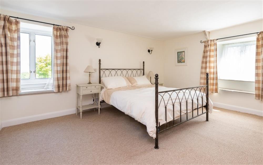 The master bedroom with a sea view from the window seat at Rest Cottage in Stokenham