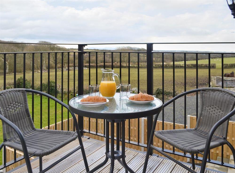 Seating on balcony commands panoramic views at Rhiwal Kitty in Bodedern near Holyhead, Gwynedd