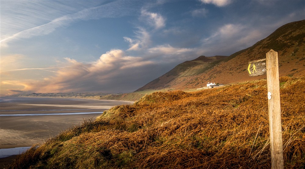 A footpath to Rhossili Bay Beach, with Rhossili Old Rectory in the background, South Wales at Rhossili Old Rectory in Rhossili, South Wales