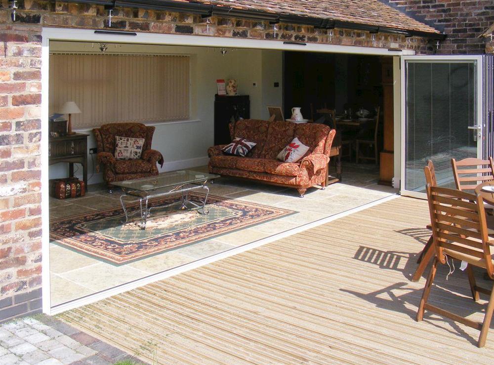 Luxurious bi-fold doors connect living room and patio at Rimmers Farmhouse in Wichenford, near Worcester, Worcestershire