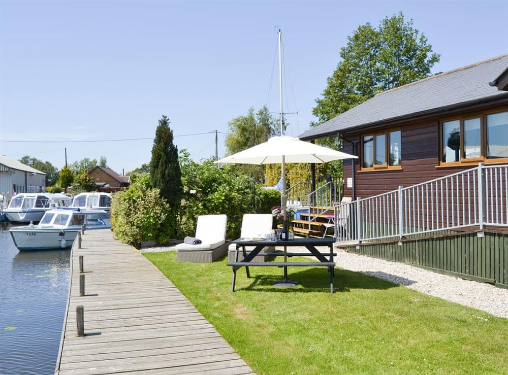 Lawned garden area with outdoor furniture at River Breeze in Brundall, Norfolk