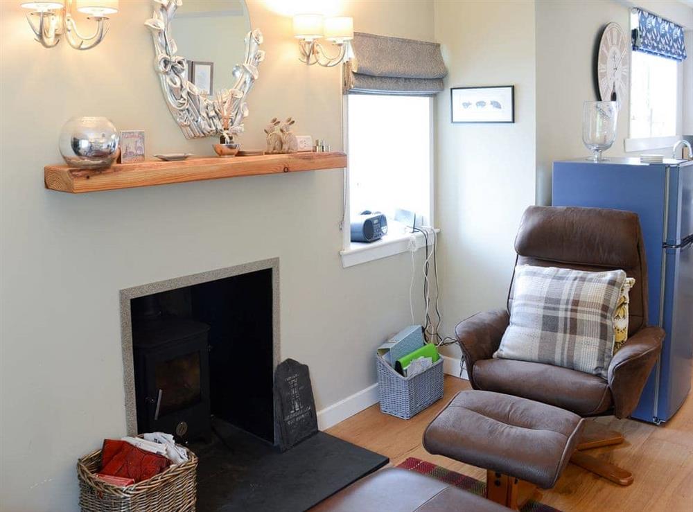 Cosy living room with wood burner at Riverside Cottage in Inchnadamph, near Lochinver, Sutherland