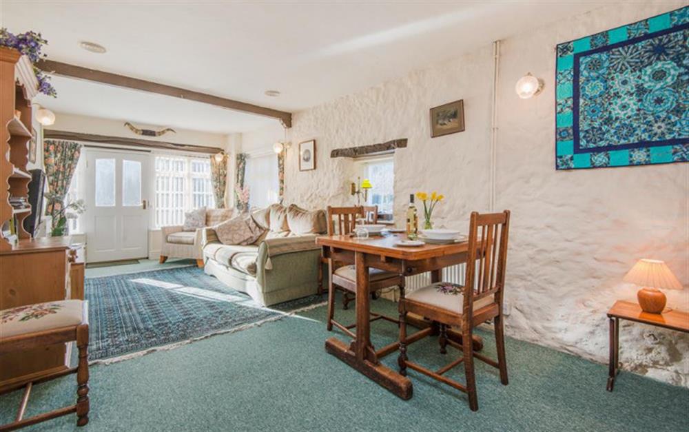 Open plan living area with dining table and chairs at Riverside Cottage in Seaton