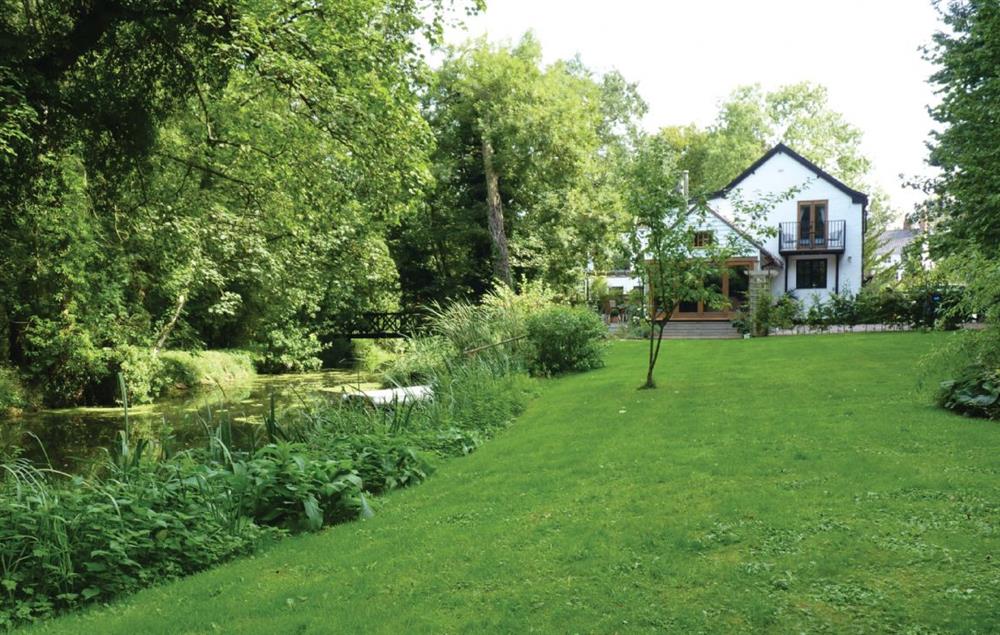 Enclosed garden with seating overlooking the river at Riverside Cottage (Suffolk), Old Water Mill