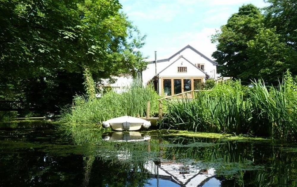 Private jetty and a four person rowing boat and a small, private island accessed via a wooden bridge at Riverside Cottage (Suffolk), Old Water Mill