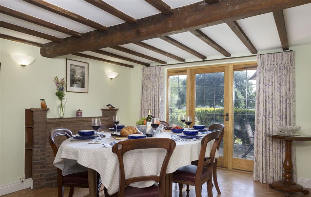 Dining room seating six guests and original beams at Riverside House, Bidford-on-Avon