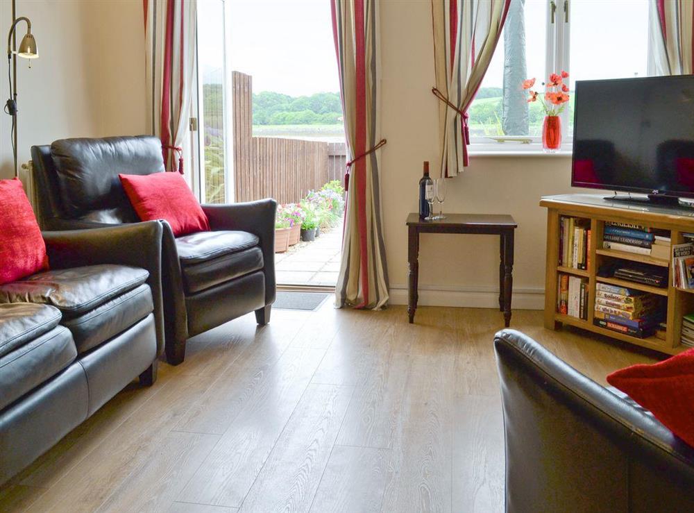 Stylish open-plan living room with French doors to enclosed riverside patio at Riverside Mews in Bideford, Devon