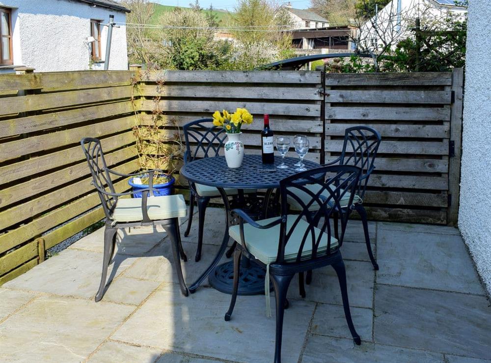Enclosed courtyard patio with garden furniture at Rock Cottage in Kendal, Cumbria