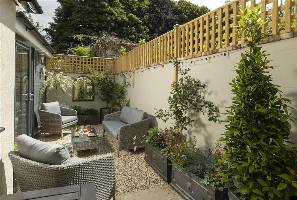 Soak up the sunshine in the pretty courtyard garden at Rock Cottage, Minchinhampton