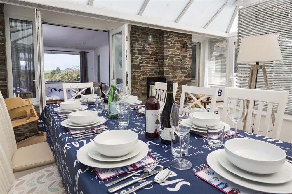 Spacious conservatory with large dining table seating up to eight guests