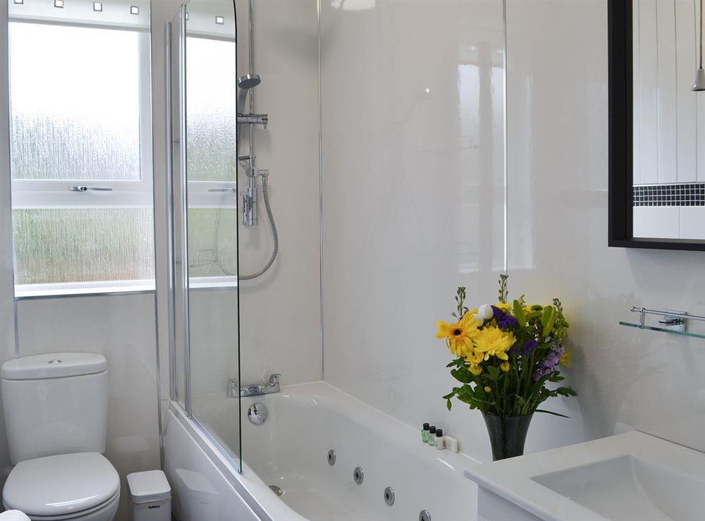 Bathroom with spa bath and shower over the bath at Rocky Mountain View in Ballachulish, Highlands, Argyll