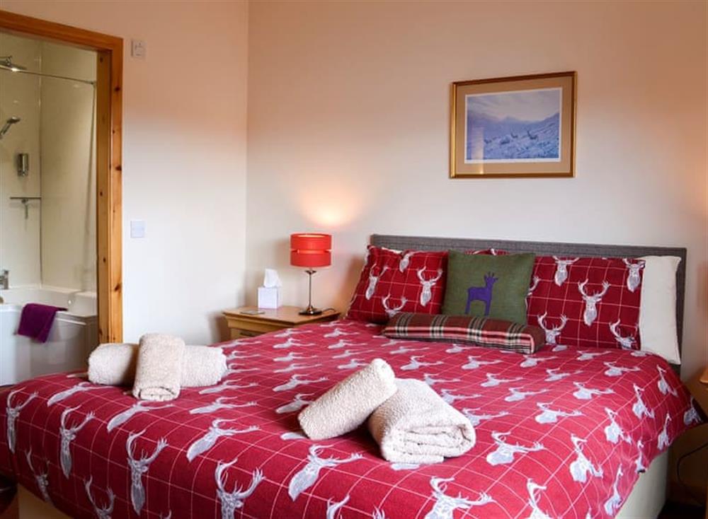 Bedroom with kingsize bed and en-suite at Roe Deer Cottage in Broallan, near Beauly, Inverness-Shire
