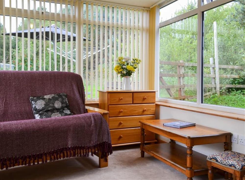 Sun room with double futon bed at Roe Deer Cottage in Broallan, near Beauly, Inverness-Shire