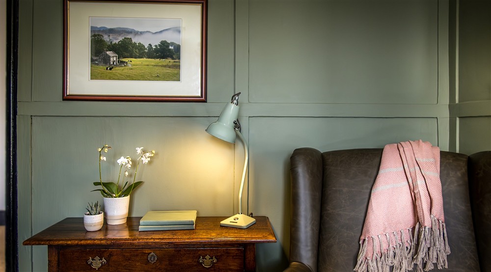 The side table and armchair in sitting room at Rose Castle Cottage in Nr Coniston, Cumbria