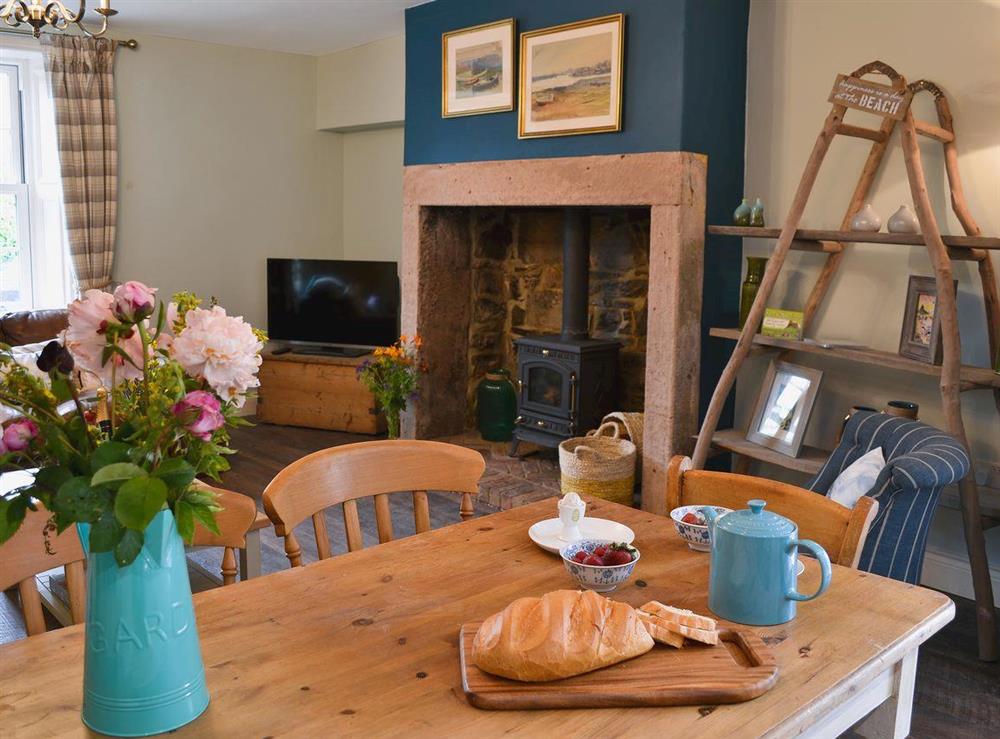 Lounge and dining area with wood burner at Rose Cottage in Beadnell, Northumberland