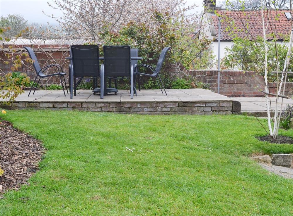 Lawned garden with raised seating area at Rose Cottage in Fylingthorpe, near Whitby, Yorkshire, North Yorkshire