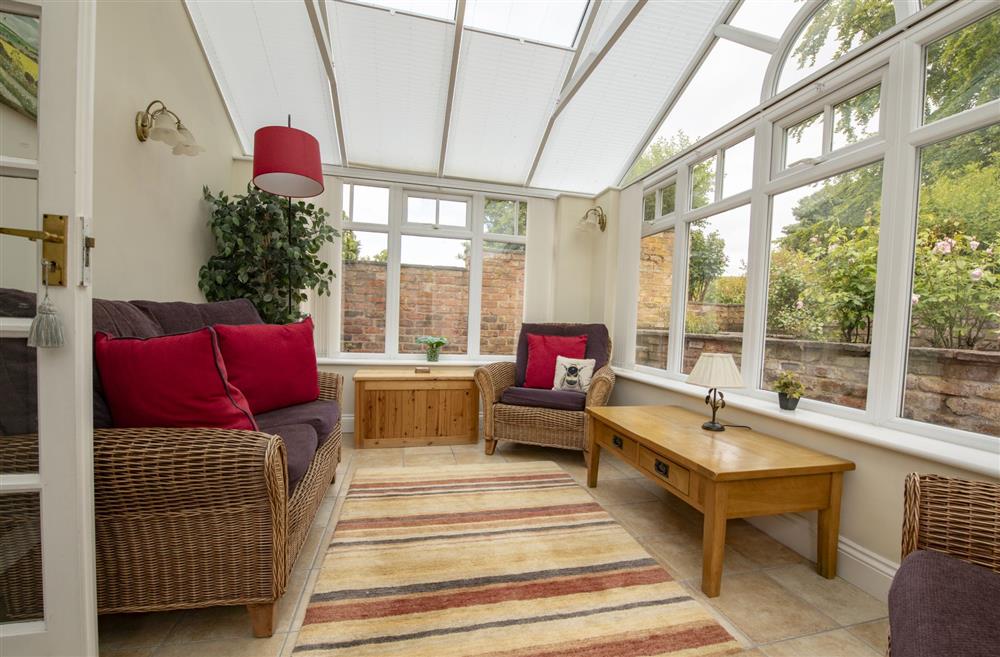 The conservatory is surrounded by the cottage’s beautiful rose beds