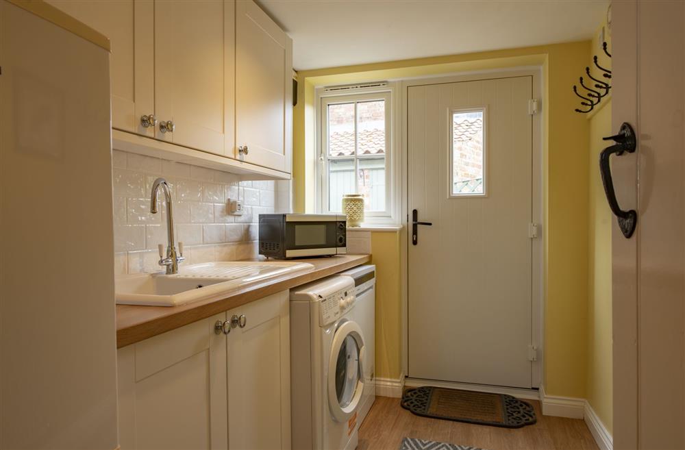 Utility room with extra fridge/freezer and hanging space for coats