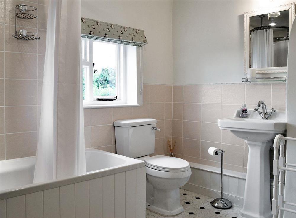 Bathroom with bath, shower attachment and toilet at Rose Cottage in Saffron Walden, Essex
