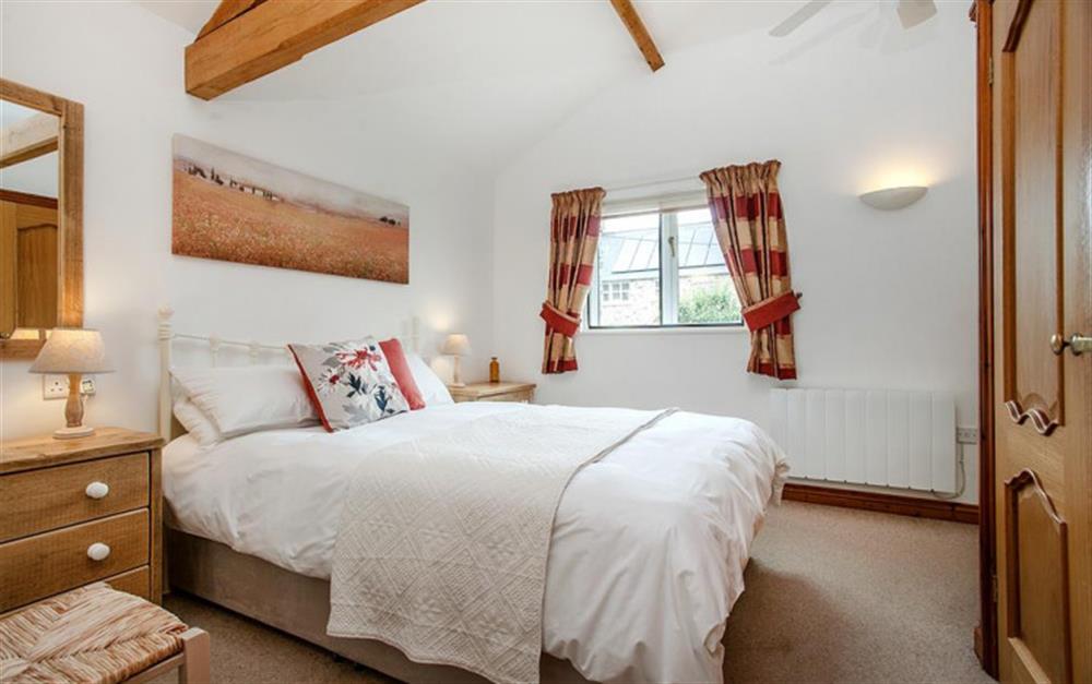 The bedroom has an en-suite shower room at Rose Cottage in Seaton