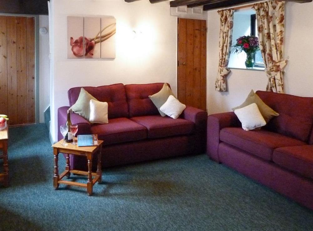 Characterful living room with exposed wood beams at Rose Cottage in Wheddon Cross, Exmoor, Somerset