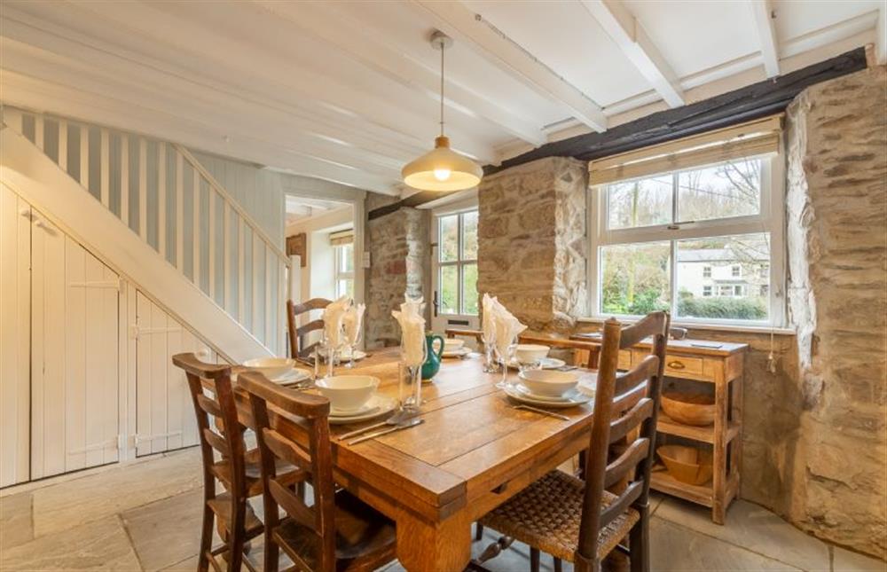 Dining area with table and an inglenook fireplace with wood burning stove at Rose in Vale Cottage, Mithian, St Agnes 