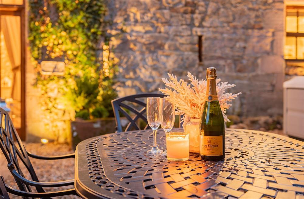 The outdoor dining table with a bottle of champagne and two glasses The private patio