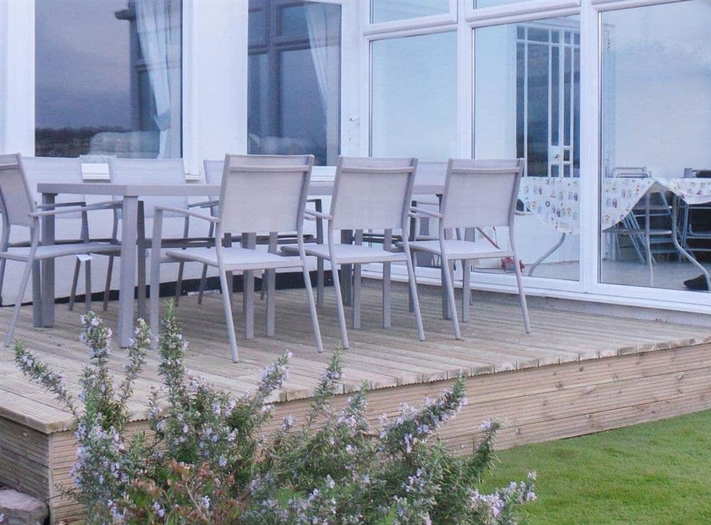 Decked area with table and chairs by the conservatory at Rosehill in Paignton, Devon