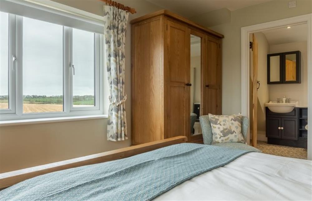 First floor: The master bedroom has an en-suite bathroom at Rosemary Cottage, Thornham near Hunstanton