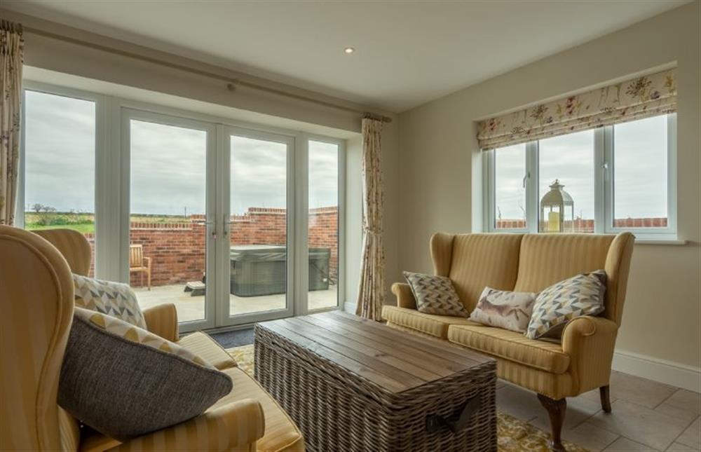 Ground floor: French doors lead into the garden from the snug at Rosemary Cottage, Thornham near Hunstanton