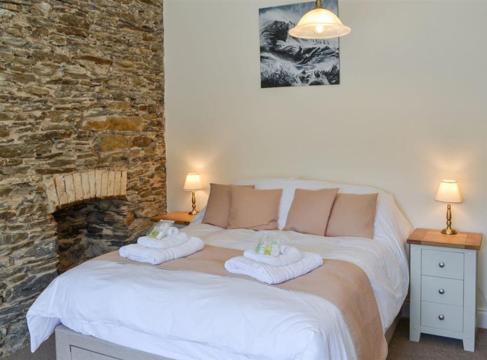 Cosy and inviting double bedroom with feature stone wall at Ocean Mist, 