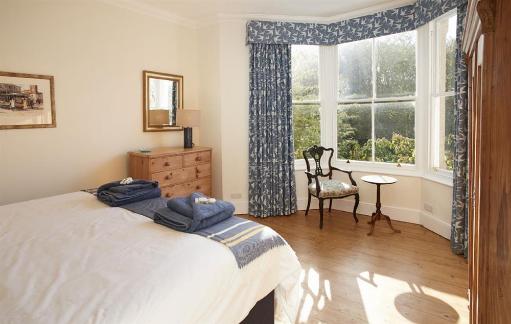 Bedroom with 6’ super king zip and link beds and bay window overlooking the garden at Rosevean House, St. Agnes