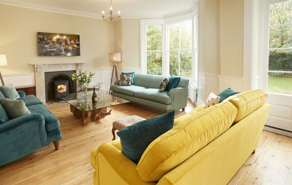 Spacious open plan sitting room with wood burning stove at Rosevean House, St. Agnes