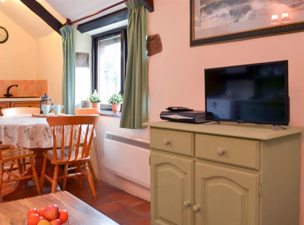 Modest dining table and chairs within the open living area at Rosewood Barn Cottage in St Neot, near Liskeard, Cornwall