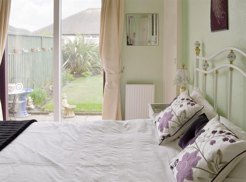 Comfortable double bedroom with patio doors to garden at Rossall Beach Cottage in Rossall, near Thornton-Cleveleys, Lancashire, England
